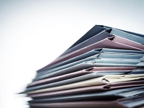 Stack of multicolored folders sitting on a desk