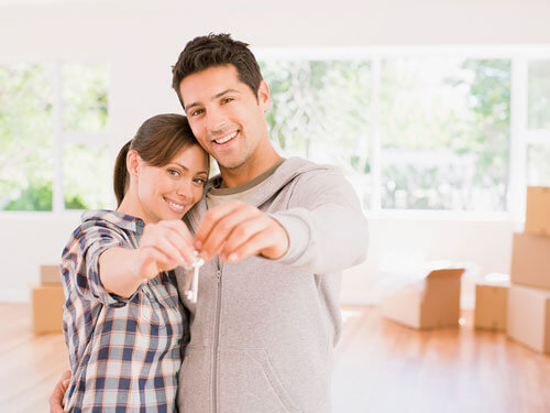 Man and a woman holding the keys to their new home